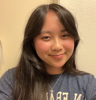 a girl smiling wearing a blue shirt with flushed cheeks
